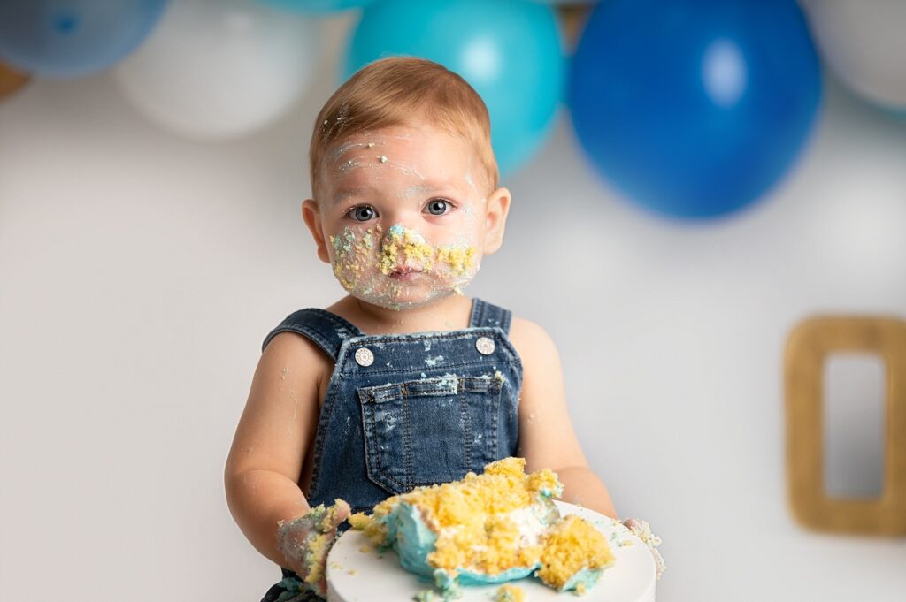 cute boy covered in cake